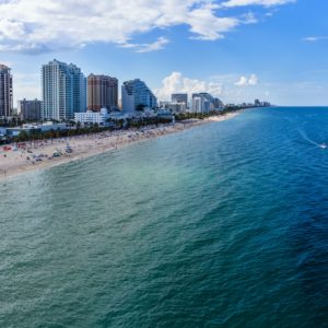fort lauderdale, FL skyline with high rise buildings looking at blue ocean and white sand beach