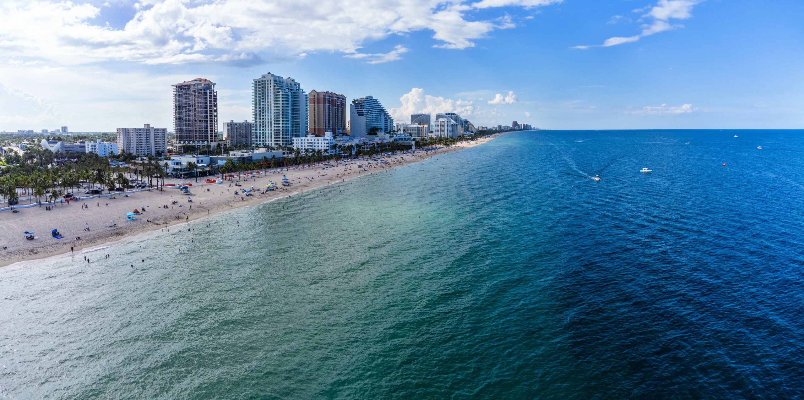 fort lauderdale, FL skyline with high rise buildings looking at blue ocean and white sand beach